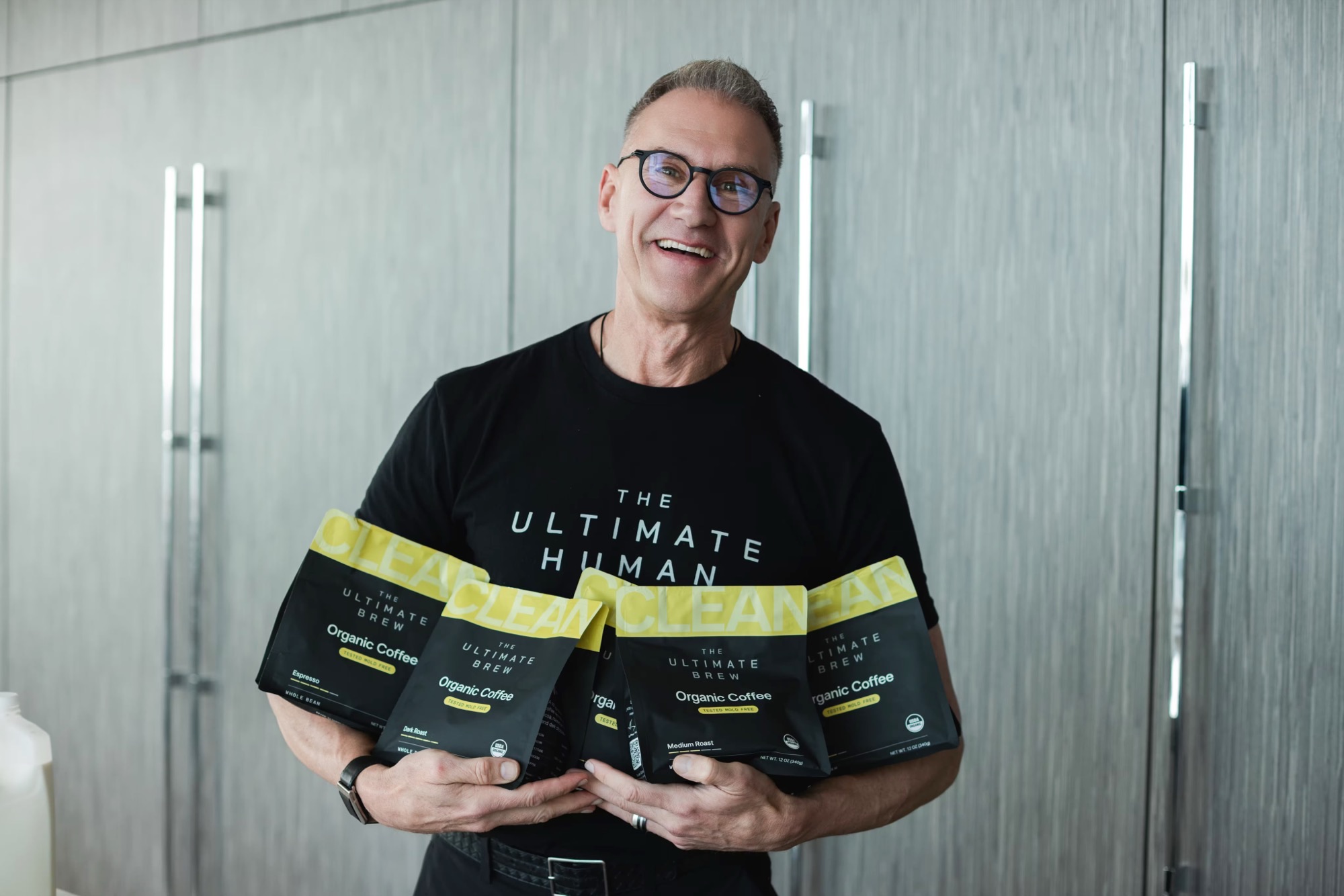 Gary Brecka holding bags of The Ultimate Brew